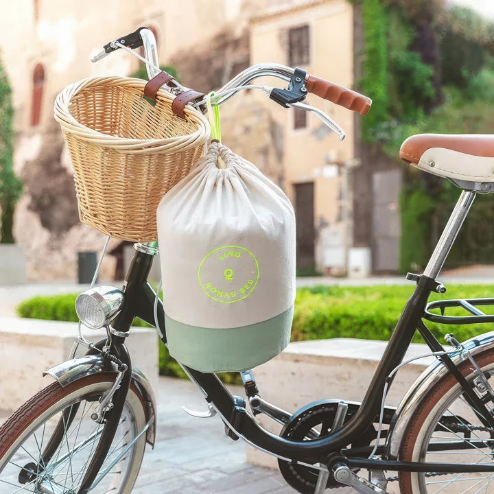 Vélo avec panier et sac attaché, dehors dans un cadre urbain pittoresque.
